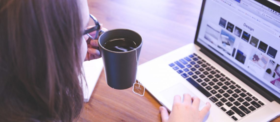 Woman Looking Online and Drinking Tea