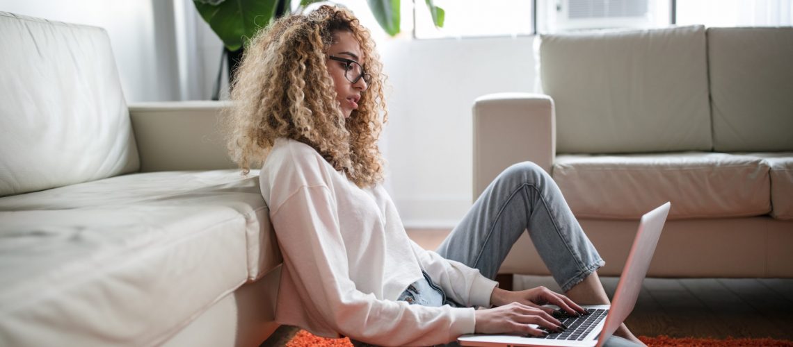 Woman Sitting on the Floor and Working From Home